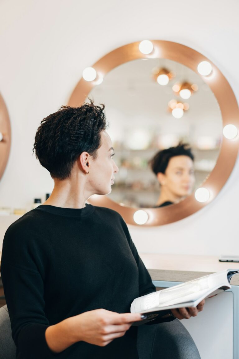 Attractive woman at the mirror in beauty studio Image description