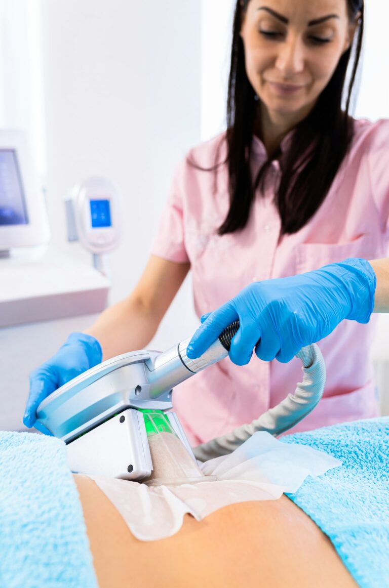 Beautician therapist applying cryolipolysis treatment in beauty salon.