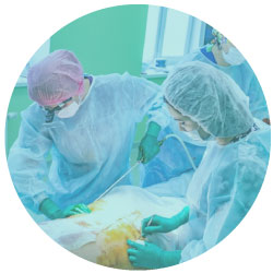 patient in surgical environment surround by doctors in scrubs injecting liposuction applicator